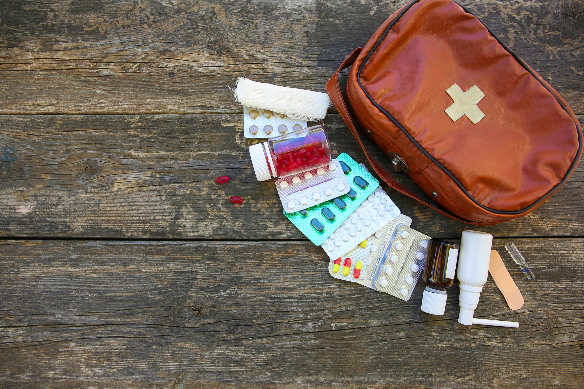 First aid kit on old wooden background. Top view. Flat lay.